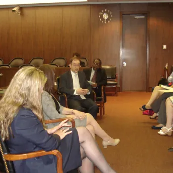 Image of public defenders speaking to teens in a courtroom