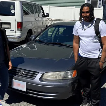 Two people in front of a vehicle as a part of an effort to help people under supervision find affordable cars.