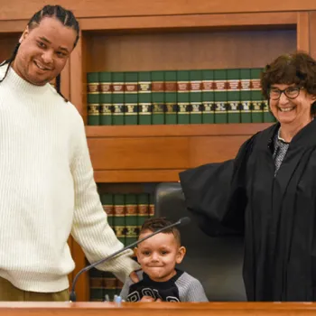 Judge Patti B. Saris in her courtroom with a reentry program graduate and his son.