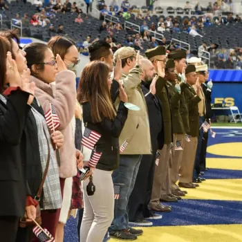 New citizens recite the Oath of Allegiance on the football field before a Los Angeles Rams game. 