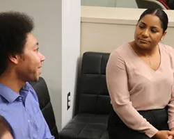 Man and woman speaking in a conference room.